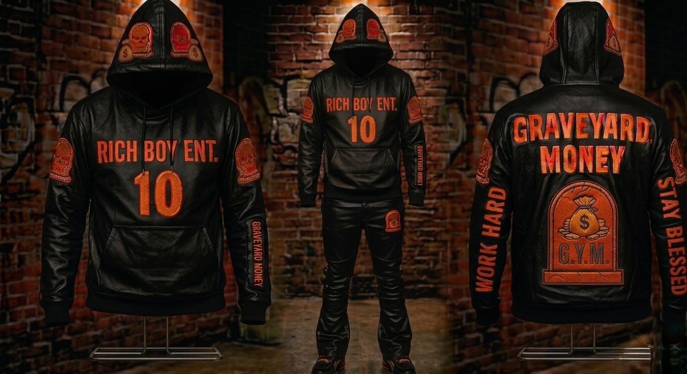 Three people wearing black jackets with orange text and a brick wall background, one with a large backpack.