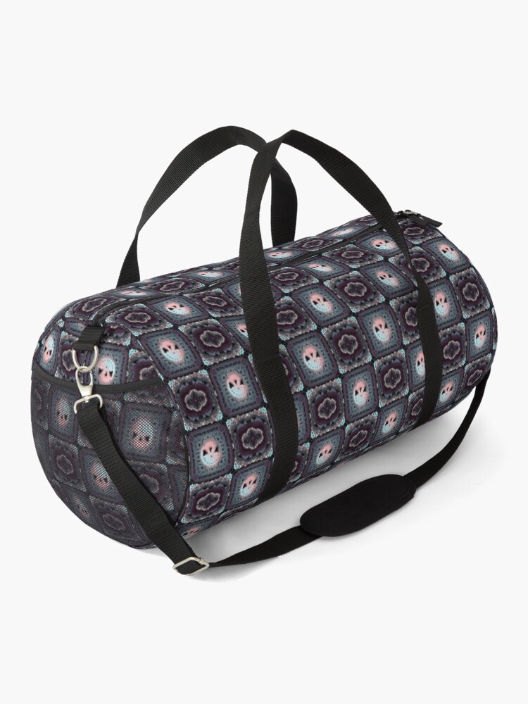 Duffle bag with a patterned design, black straps, and a zipper, on a white background.