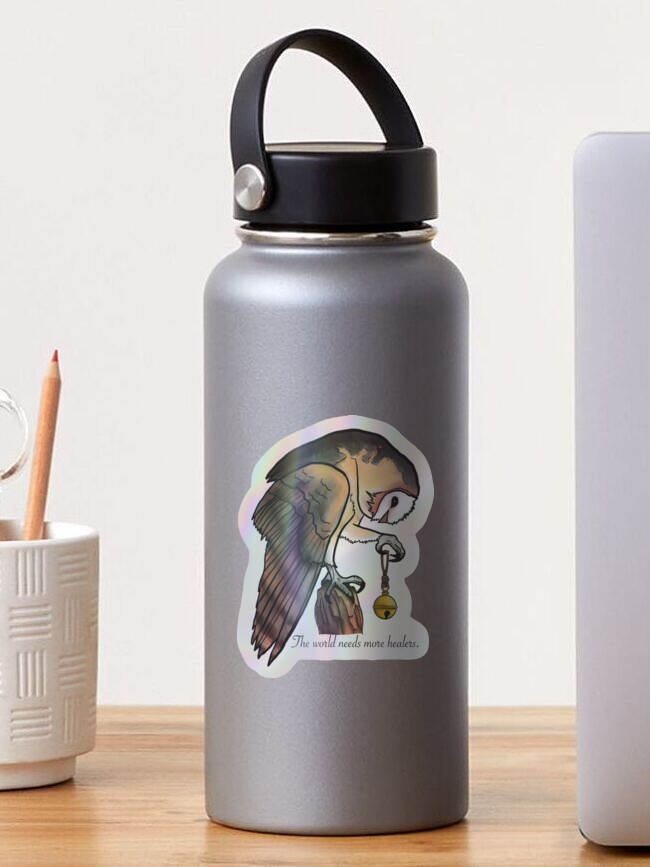 Silver water bottle with a tattoo-style lion illustration, black handle, on a wooden surface next to a white container and a laptop.