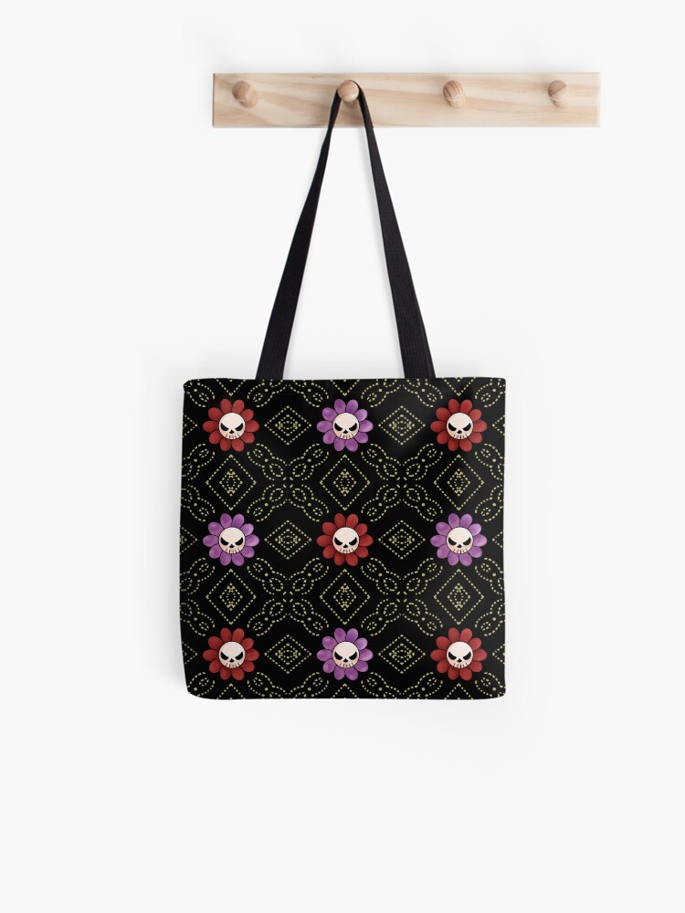 Black tote bag with purple and red floral patterns hanging from a wooden hook.