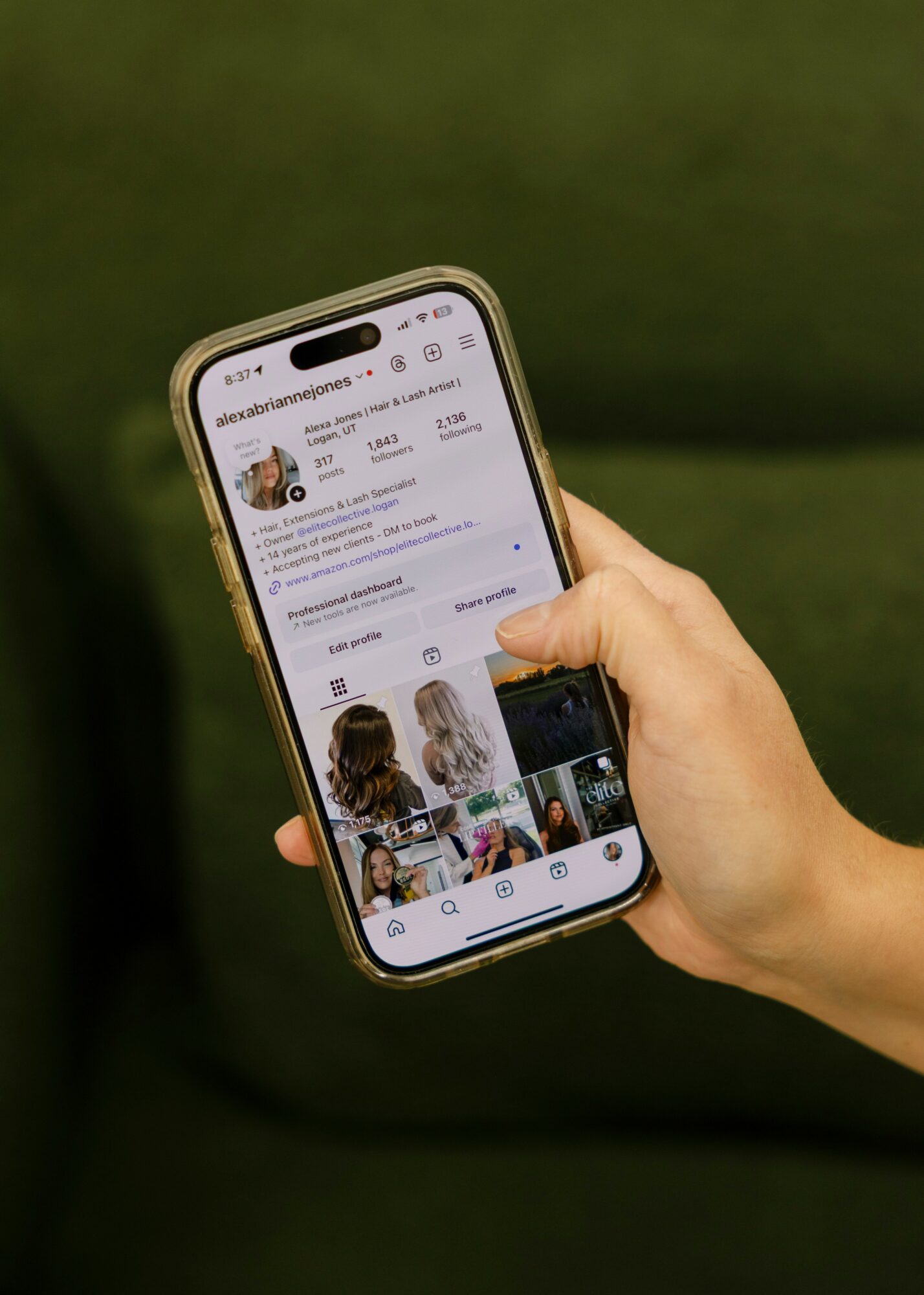 Person holding a smartphone displaying a social media profile with images and text, against a green background.