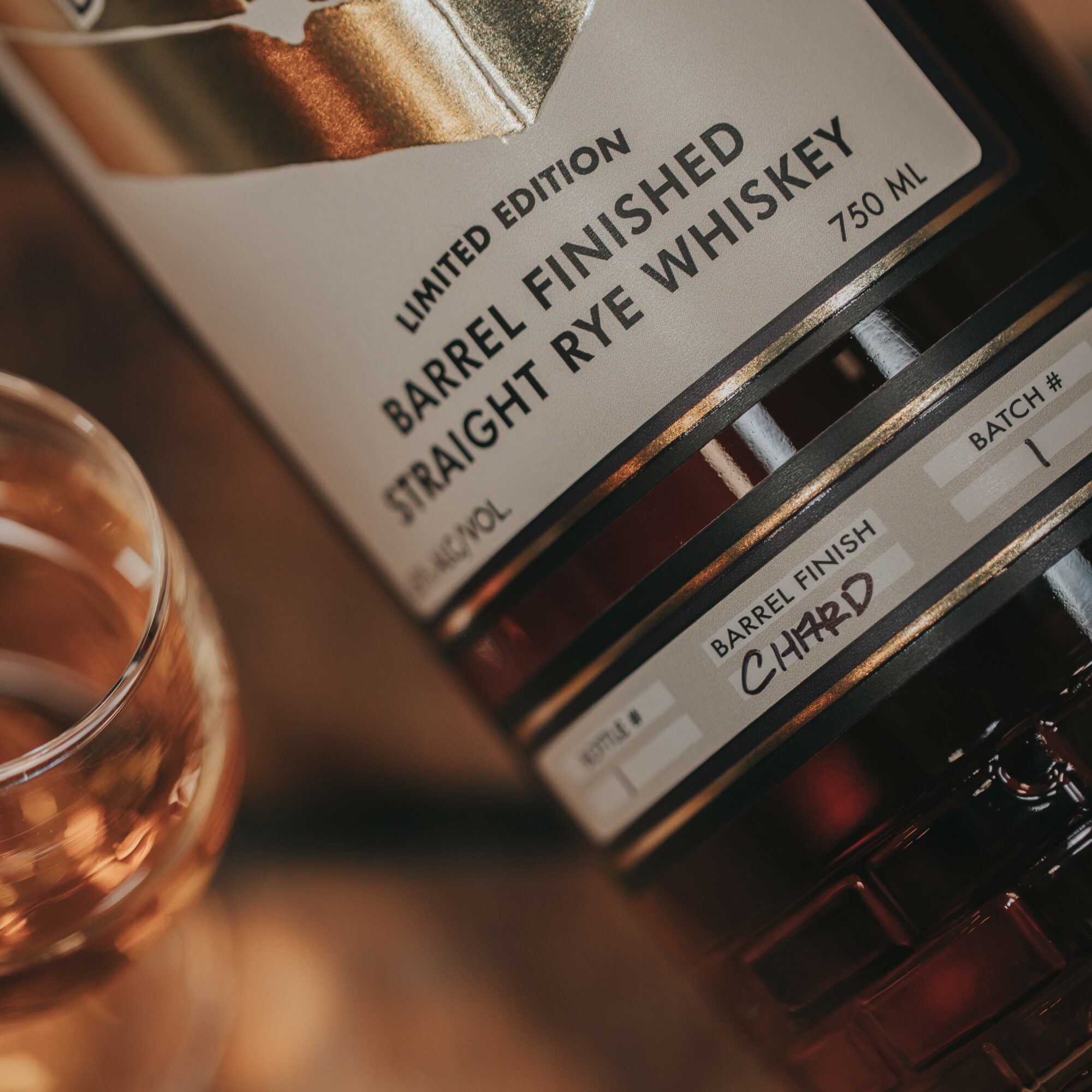 Close-up of whiskey bottle label showing limited edition, barrel finished, straight rye whiskey, 750 ml, batch number, and charred barrel finish.