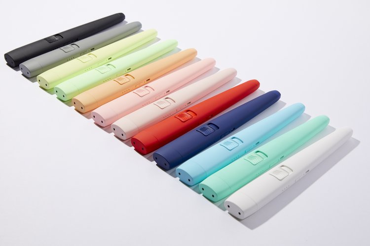 Row of colorful pens in black, gray, green, orange, pink, red, blue, turquoise, and white on white background.